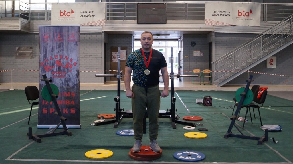 apbalvošana svara stieņa spiešanā guļus